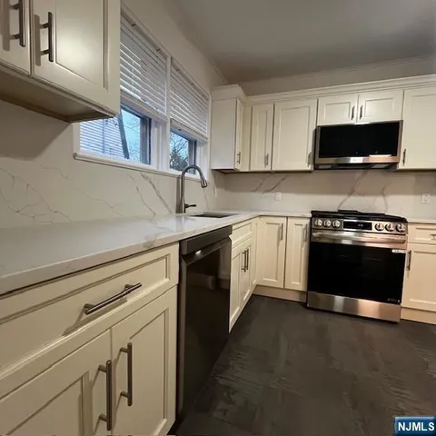 a kitchen with stainless steel appliances white cabinets and a stove top oven