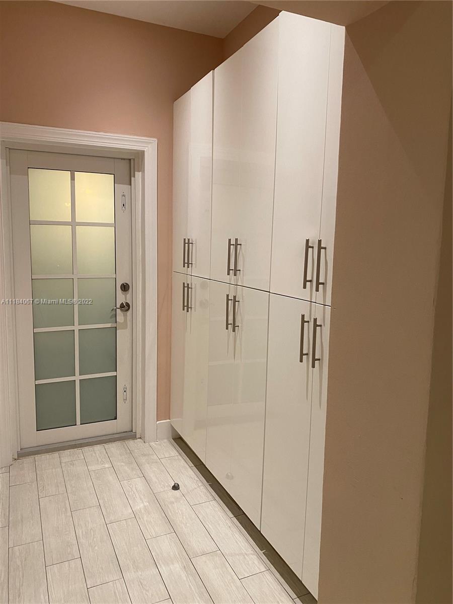 1136 Alhambra Circle Coral Gables, FL 33134 - Photo 16 of 67 a view of an empty room with wooden floor and a window