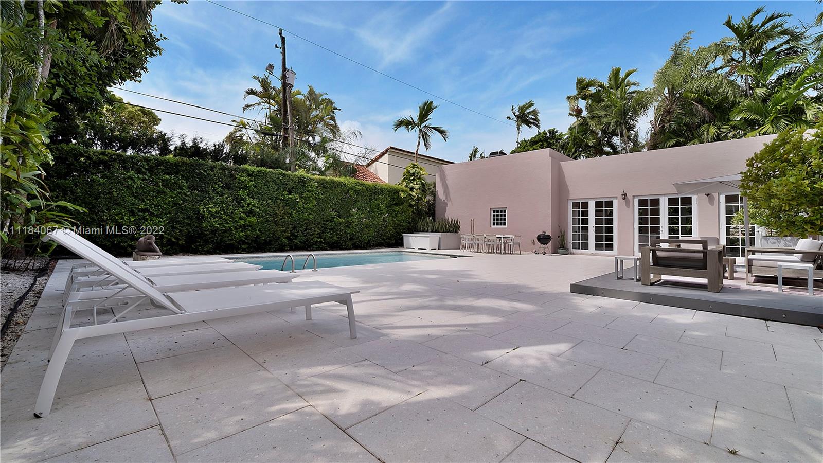 1136 Alhambra Circle Coral Gables, FL 33134 - Photo 47 of 67 a view of a white house with a yard and potted plants