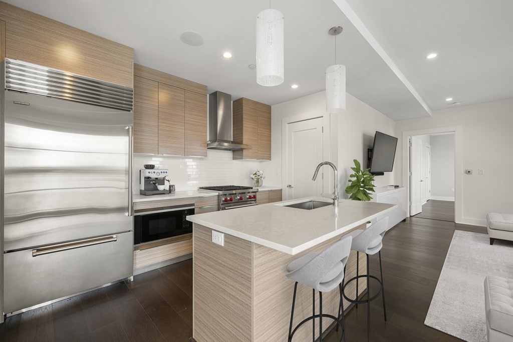 14 West Broadway, Unit 803 Boston, MA 02127 - Photo 1 of 42 a kitchen with stainless steel appliances kitchen island granite countertop a stove a sink and a refrigerator