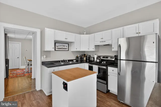 a kitchen with a stove a refrigerator and a sink
