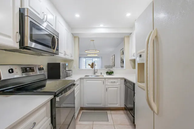 a kitchen with stainless steel appliances a stove microwave and sink