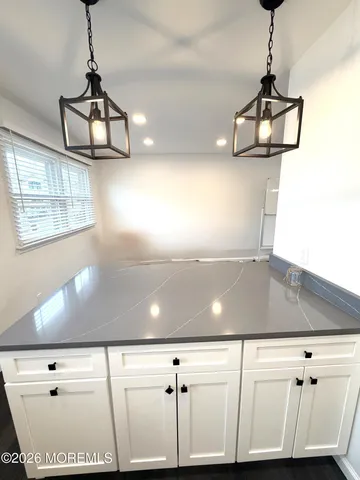 a room with a chandelier fan and wooden floor
