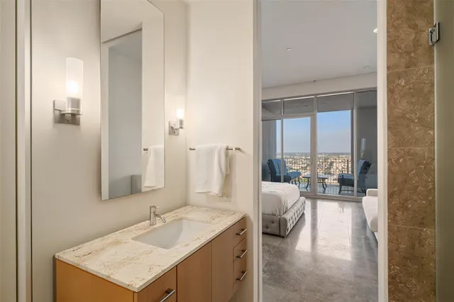 a en suite bathroom with a granite countertop sink and a mirror