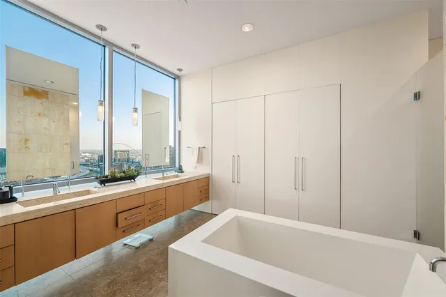 a bathroom with a tub a sink and a large mirror