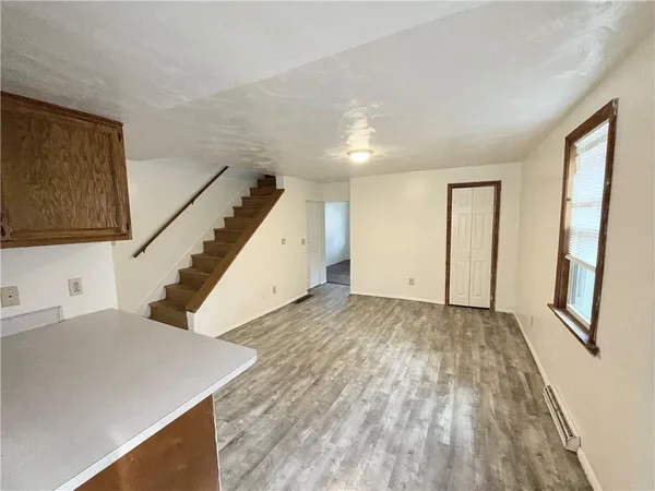 a view of an empty room with wooden floor