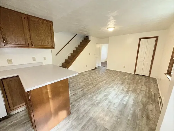 a view of a kitchen with wooden floor and cabinets