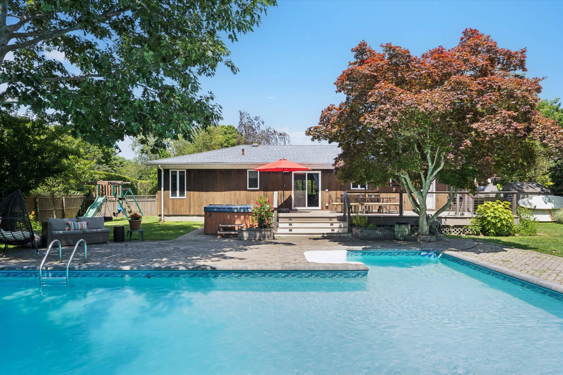 27 South Country Road Westhampton, NY 11977 - Photo 2 of 16 a view of a patio with table and chairs under an umbrella