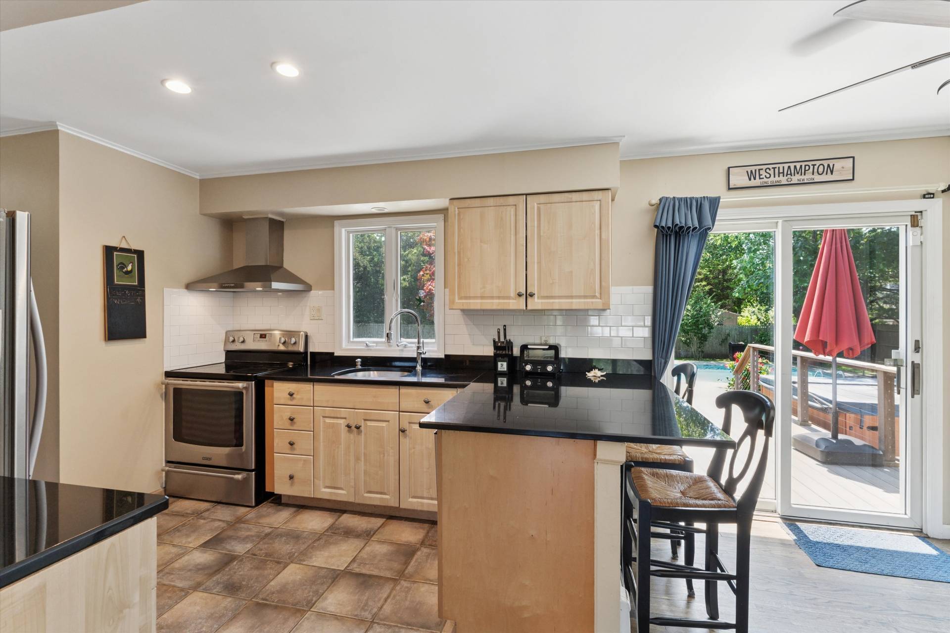 27 South Country Road Westhampton, NY 11977 - Photo 5 of 16 a kitchen with granite countertop a stove a sink and a dining table