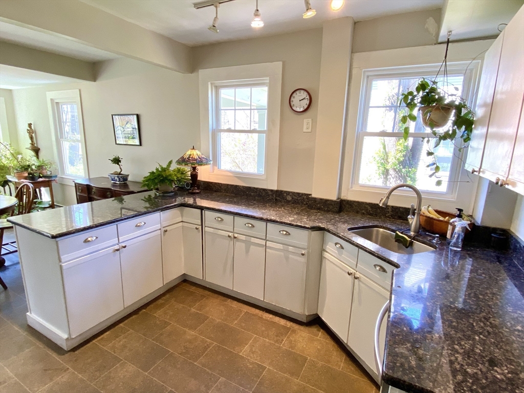 14 Nutting Avenue Amherst, MA 01002 - Photo 4 of 41 a large kitchen with granite countertop a stove a sink a window and white cabinets