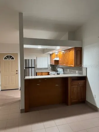 a kitchen with granite countertop a refrigerator and a sink