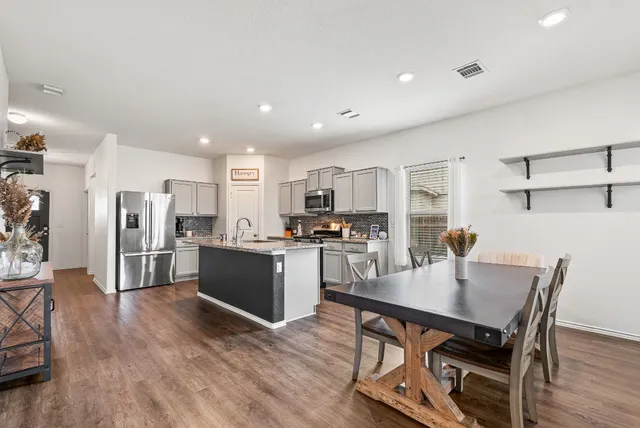 a large kitchen with a table and chairs