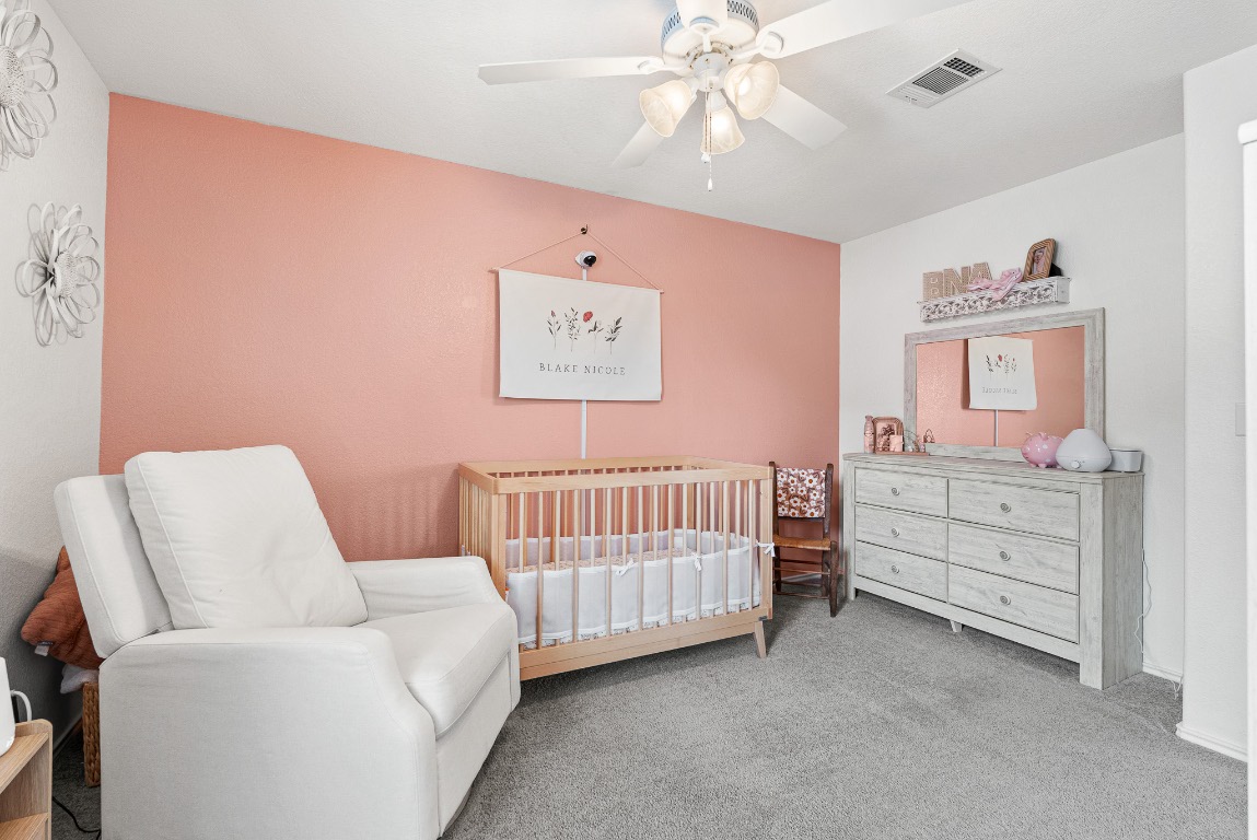 136 Copper Lane Kyle, TX 78640 - Photo 27 of 33 a bedroom with a bed and a chandelier