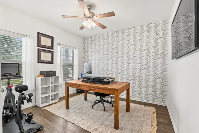 a view of a workspace with furniture and a window