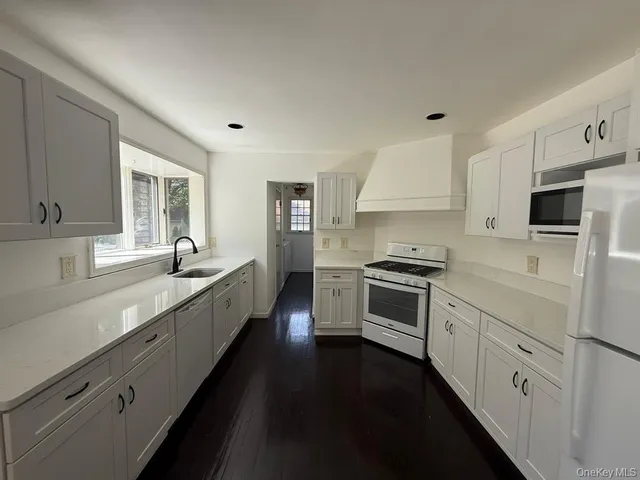 a large kitchen with a stove top oven sink and cabinets