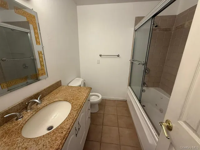 a bathroom with a granite countertop sink toilet and shower a mirror