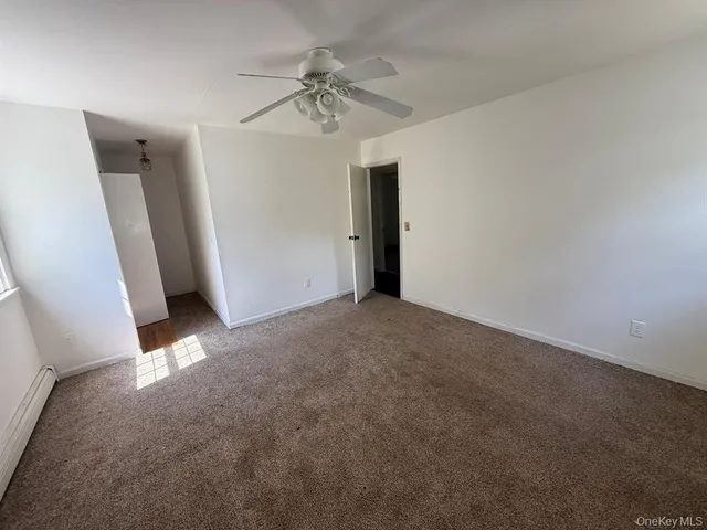 en empty room with windows and ceiling fan