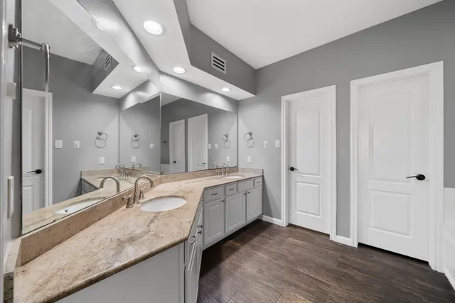 a spacious bedroom with a bed and wooden floor