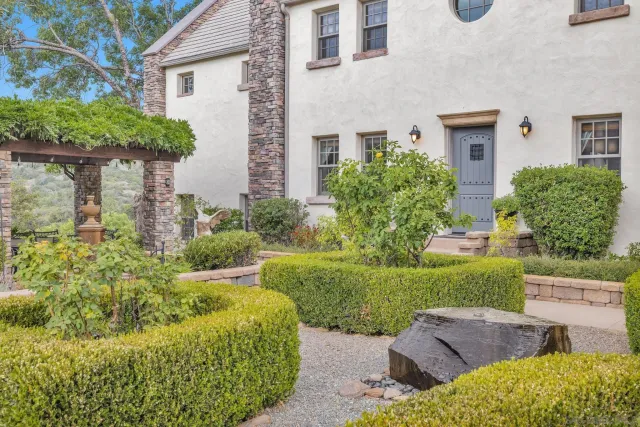 front view of house with a yard and potted plants