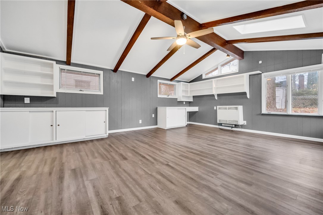 1605 Laclede Road Cleveland, OH 44121 - Photo 35 of 40 Unfurnished living room featuring vaulted ceiling with skylight, wood finished floors, ceiling fan, and heating unit
