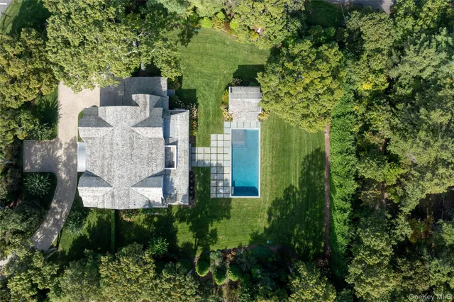 an aerial view of a house with plants and large trees