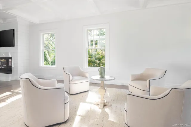 a living room with furniture a flat screen tv and a window