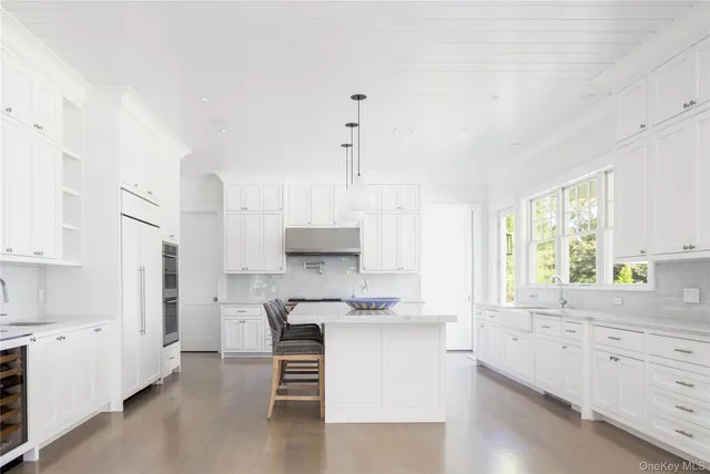 a kitchen with white cabinets and window