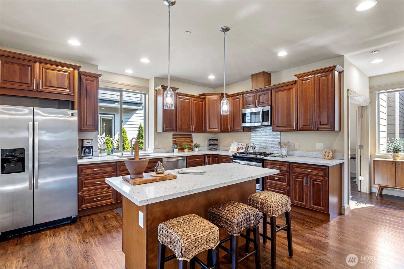 553 Southeast Andrews Street, Unit B Issaquah, WA 98027 - Photo 12 of 28 a kitchen with a refrigerator a stove a sink a dining table and chairs