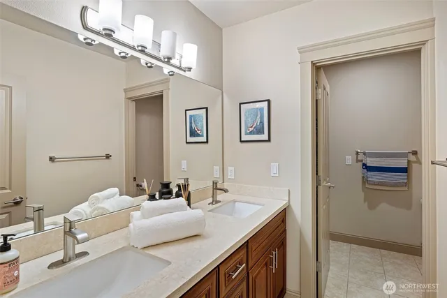a en suite bathroom with a granite countertop sink a mirror and shower