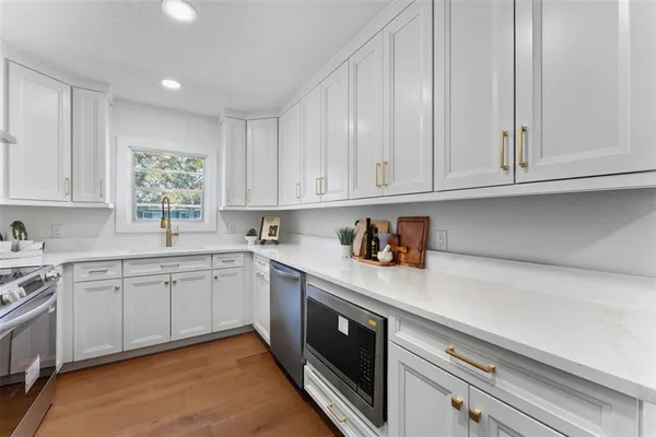 a kitchen with stainless steel appliances granite countertop a sink dishwasher stove and cabinets