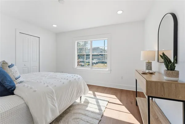 a bedroom with a bed a mirror and a window