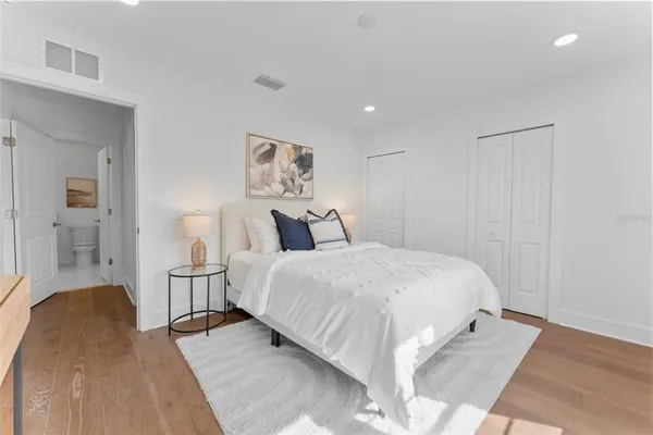 a bedroom with a bed and a painting on the wall