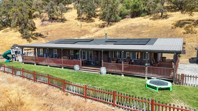 a view of house with a yard and sitting area