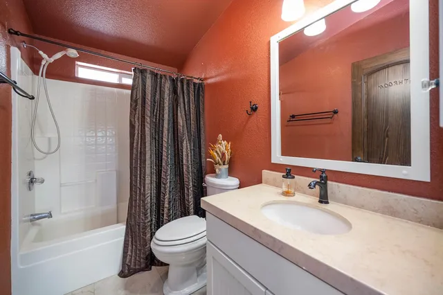 a bathroom with a granite countertop sink toilet and shower