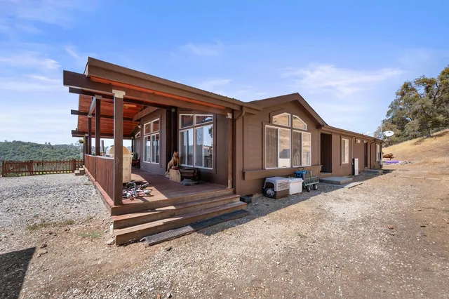 a view of a house with backyard and sitting area