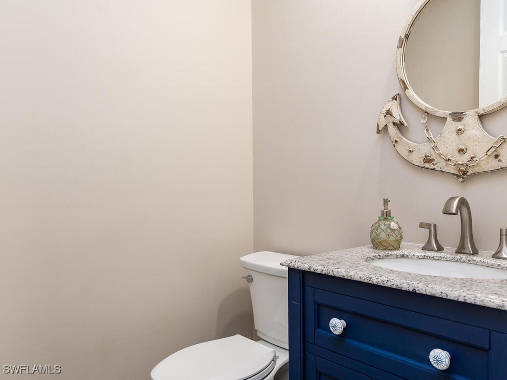 16410 Oakview Circle Alva, FL 33920 - Photo 14 of 39 a bathroom with a granite countertop toilet sink and mirror