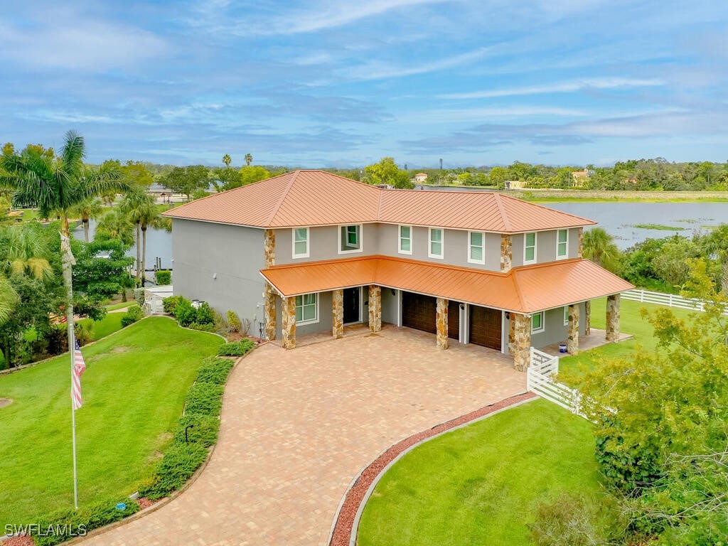 16410 Oakview Circle Alva, FL 33920 - Photo 2 of 39 a view of a white house with a big yard and palm trees