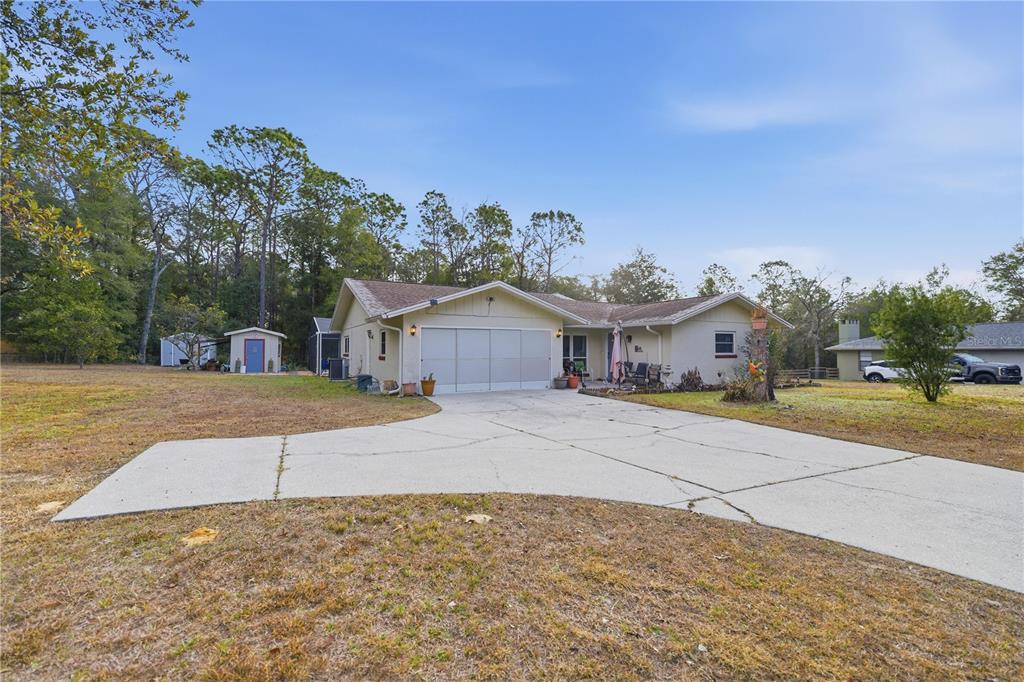 8951 Southwest 202nd Avenue Road Dunnellon, FL 34431 - Photo 27 of 38 a front view of a house with a yard and garage