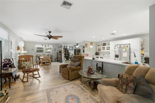 a living room with lots of furniture and view of kitchen
