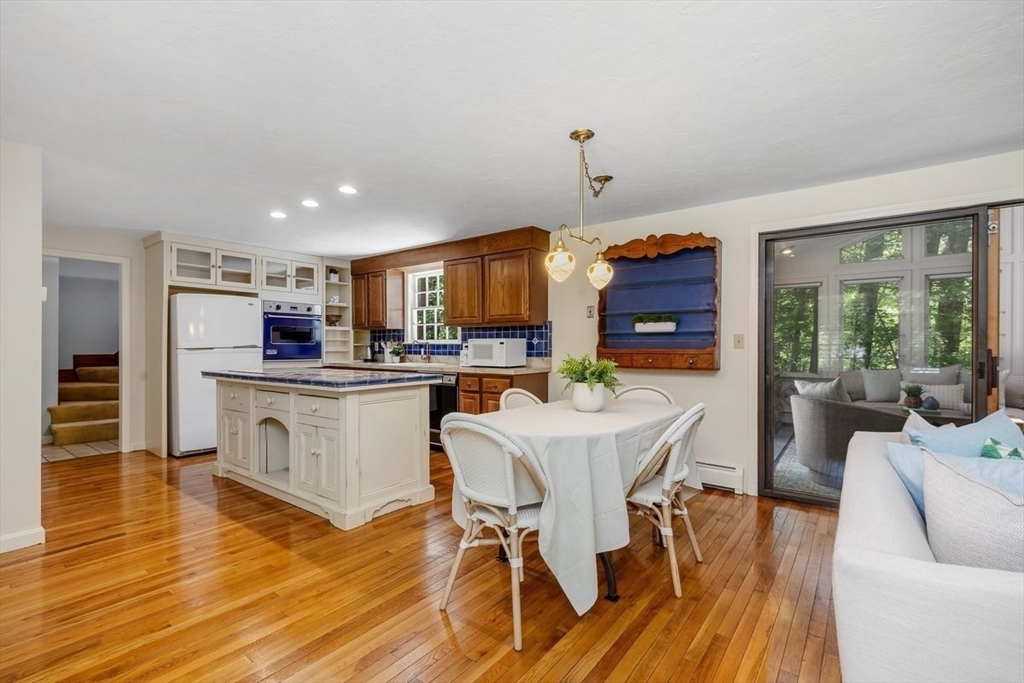 445 Cushing Street Hingham, MA 02043 - Photo 5 of 29 a kitchen with stainless steel appliances a dining table chairs stove and a refrigerator