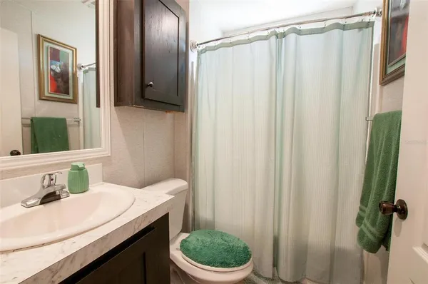 a bathroom with a sink a toilet and shower curtain