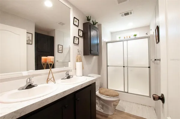 a bathroom with a granite countertop sink toilet and shower