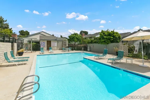 a view of a house with pool and chairs