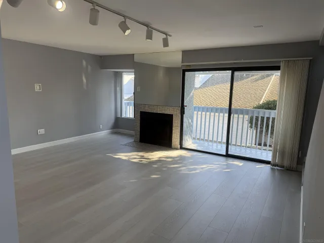 an empty room with wooden floor and a window