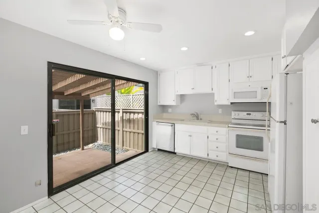 a kitchen with granite countertop a stove a sink and a refrigerator