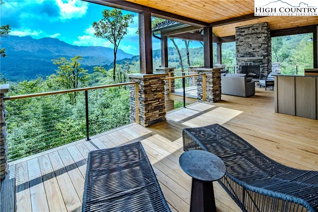 a view of a patio with couches chairs potted plants and wooden floor