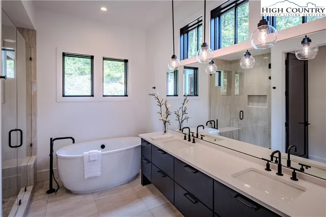 a bathroom with a double vanity sink a mirror and a bathtub
