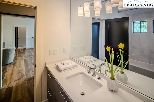 a bathroom with a sink a mirror and a shower