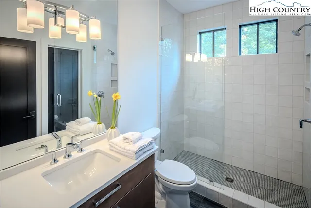 a bathroom with a sink a toilet and shower