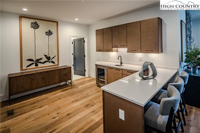 a kitchen with stainless steel appliances granite countertop a sink dishwasher stove and refrigerator with wooden floor